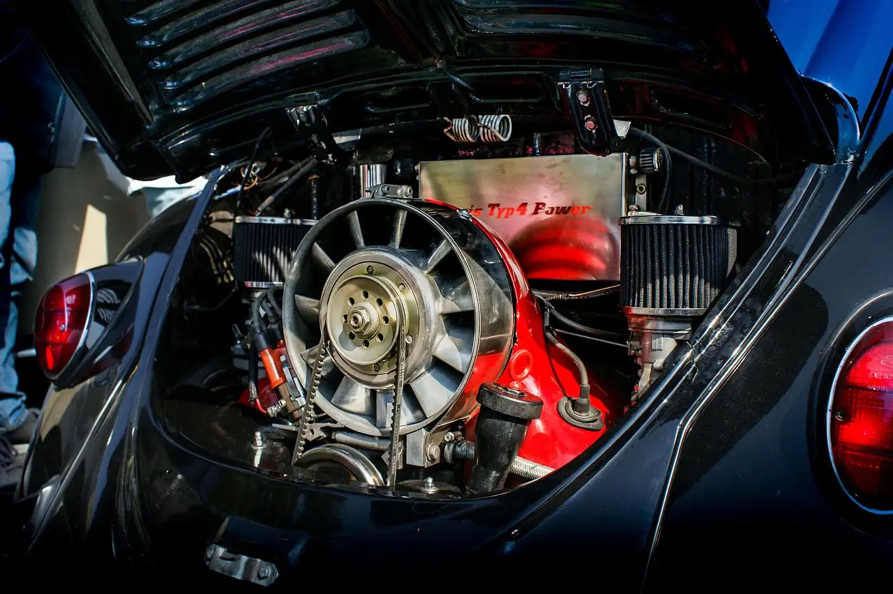 Car owner checks a dusty engine air filter beside an open hood in daylight