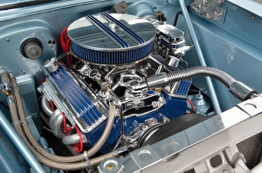 Car owner checking the owner’s manual and oil cap beside an open hood