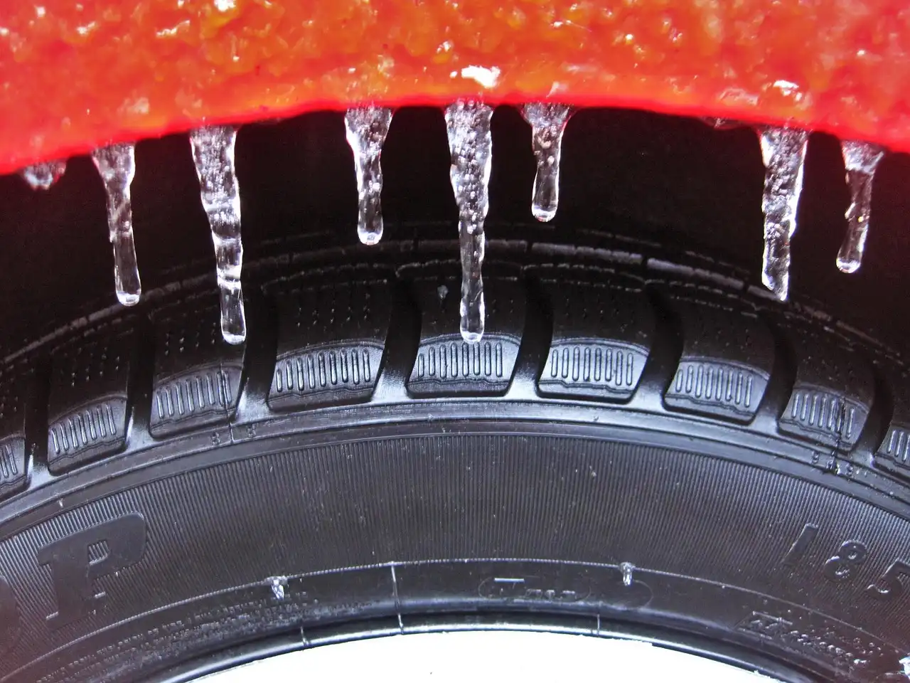 Compact SUV driving through fresh snow on a suburban road, highlighting winter tires vs all-season tires in snow